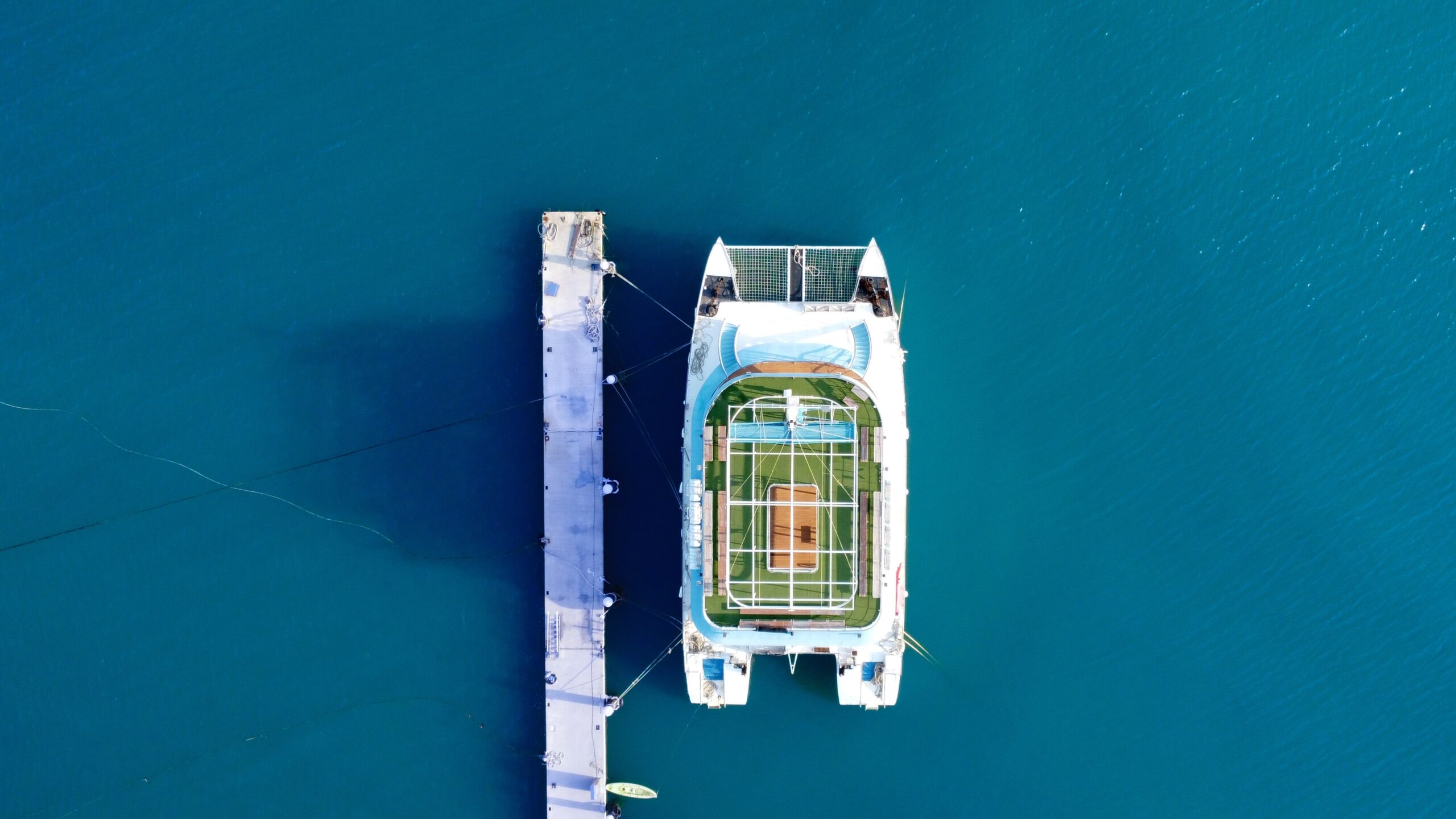 aerial birds-eye-view image of a power catamaran moored alonside a dock