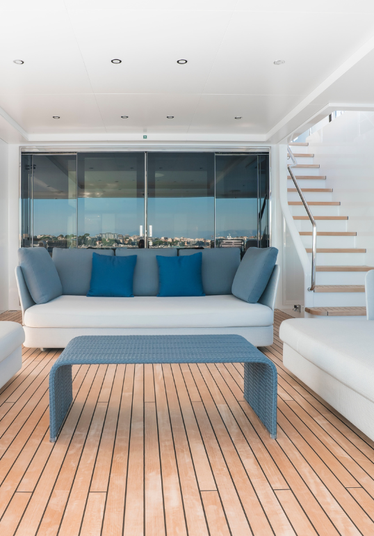 The main aft deck on a superyacht featuring a companionway and blue furniture